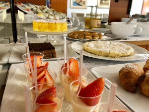 a table topped with plates of desserts and fruit in glasses at Hotel Zanetti in Torri del Benaco