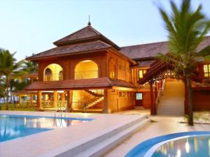 una casa grande con piscina frente a ella en Lakesong Resort, en Kumarakom