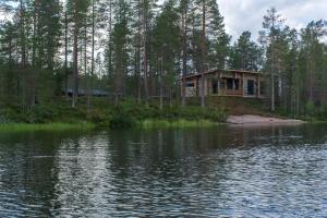 a house in the woods next to a body of water at Villa Konttaisenranta in Ruka