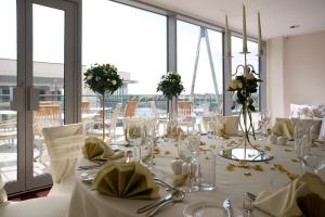 a dining room with a white table with flowers on it at Waterfront Southport Hotel in Southport