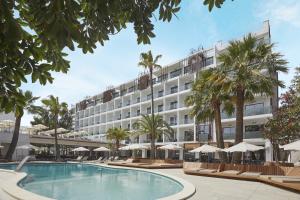 a hotel with a pool and palm trees and umbrellas at Bordoy Alcudia Port Suites in Port d'Alcudia