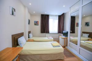 a hotel room with two beds and a desk at Guest House Amore in Sandanski