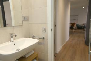 a bathroom with a sink and a mirror at Viviendas Oviedo Catedral in Oviedo