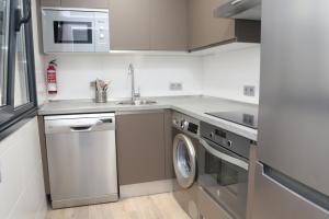 a kitchen with a washing machine and a sink at Viviendas Oviedo Catedral in Oviedo