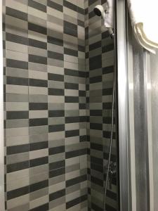 une douche avec un mur carrelé noir et blanc dans l'établissement Hostal Argentina, à Cáceres