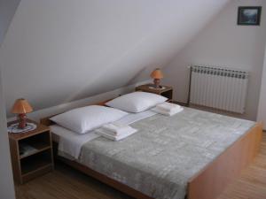 a bedroom with a bed with two night stands and two lamps at Apartments Sven in Rastovača