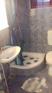 La salle de bains est pourvue d'un lavabo, d'une baignoire et de toilettes. dans l'établissement Apartment Aralo - Veraja, à Drače