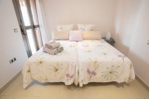Deluxe Playa Pacifico في مالقة: غرفة نوم بها سرير كبير وعليه زهور