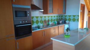 a kitchen with wooden cabinets and a black appliance at Russo's Hostel in Setúbal