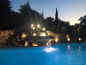 a fountain in the middle of a pool at night at Kalavrita Canyon Hotel & Spa in Kalavrita