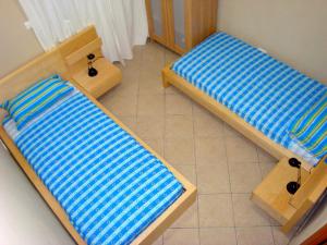 two beds with blue and white sheets in a room at Appartamento a pochi passi dal mare con Wi-Fi Gratuito in Santa Caterina dello Ionio