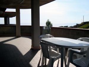 a table and chairs on a patio with a view of the ocean at Appartamento a pochi passi dal mare con Wi-Fi Gratuito in Santa Caterina dello Ionio