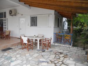 a patio with a table and chairs in front of a house at Glaros Studios in Loutra Edipsou
