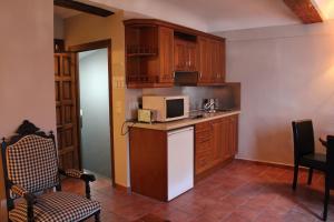 uma cozinha com um frigorífico e um micro-ondas em Posada San Martin em Cuenca