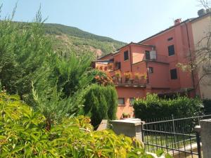 una casa en una colina con arbustos y árboles en Albergo Montenerone, en Piobbico