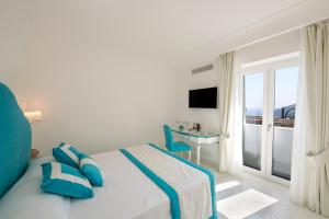 een slaapkamer met een bed met blauwe kussens en een tafel bij Villa Viviani in Amalfi