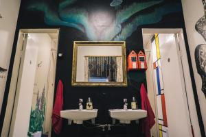 a bathroom with two sinks and a painting on the wall at The Freezer Hostel & Culture Center in Hellissandur