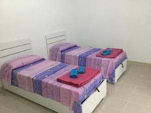 2 camas en una habitación con sábanas rosas y moradas en Ocurniciell B&B, en Nápoles