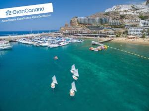 a group of boats in the water near a harbor at Sunny Apartment Puerto Rico in Puerto Rico de Gran Canaria