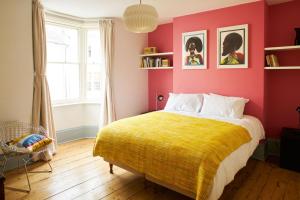 ブライトン＆ホーブにあるLovely 4 bed house 200m from the beachの黄色い毛布が掛けられたベッドのある寝室