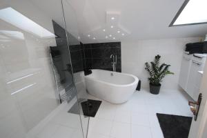 a white bathroom with a tub and a glass shower at Stanzl Haus in Kaltenbach +38 photos