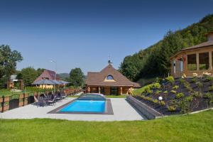 a house with a swimming pool in a yard at Agrodomki z bali Konradow in Konradów