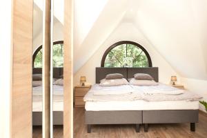 a bedroom with two beds and two mirrors at Agrodomki z bali Konradow in Konradów +106 photos