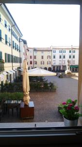 eine Terrasse mit einem Sonnenschirm und einem weißen Regenschirm in der Unterkunft L'angolo di Filippo I in Cividale del Friuli