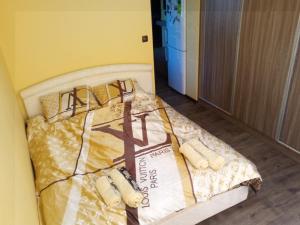 een bed in een kamer met een gele muur bij Studio Lux in Pleven
