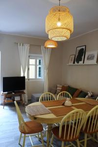 comedor con mesa, sillas y TV en Kondessa Corfu Old Town Apartment, en Corfú
