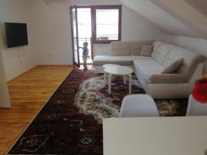 a living room with a white couch and a table at Apartman Đoković in Višegrad