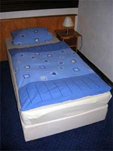 フレールスハイムにあるHotel Waldesruhの青いシーツと青い枕が備わる客室のベッド1台分です。