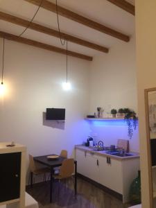 a kitchen with a sink and a table in a room at Casa Vittoria in Salerno