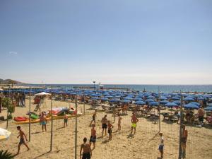 um grupo de pessoas em uma praia com guarda-sóis em San Michele em Arma di Taggia