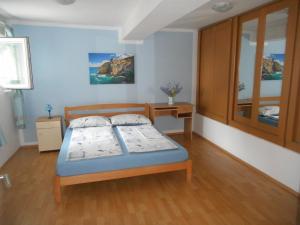 a bedroom with a bed and a wooden floor at Apartman Sara in Matulji
