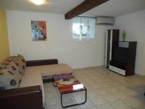 a living room with a couch and a tv at Apartman Sara in Matulji