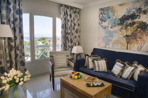 a living room with a blue couch and a table at Taba Sands Hotel & Casino - Adult Only in Taba