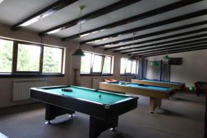 two pool tables in a large room with windows at Pensiunea Skiland in Muntele Băişorii