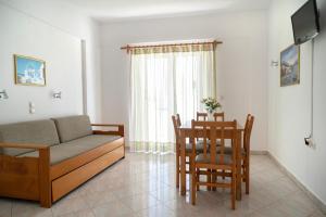 Hotel Mimoza في أييا مارينا نيا كيذونياس: غرفة معيشة مع أريكة وطاولة وكراسي
