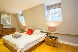 The Escalier Mews - Bright 3BDR Home في لندن: غرفة نوم بسرير ونوافذ