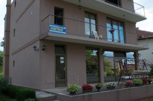 a building with a balcony with a sign on it at Guest House Dimitrije in Niška Banja