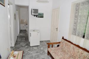 a living room with a couch and a tv on the wall at Tiros Apartments Armonia in Tyros