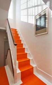 an orange staircase in a home with a picture on the wall at Stylish Seaside Maisonette - 200m to Beach in Brighton & Hove