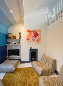 a living room with two couches and a fireplace at Stylish Seaside Maisonette - 200m to Beach in Brighton & Hove