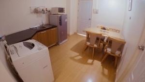 a small kitchen with a washer and a table at P.A. Ville Hotel in Nakhon Sawan