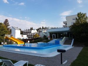 a swimming pool with a slide in front of a building at Appartements im Predigtstuhl Resort in Sankt Englmar