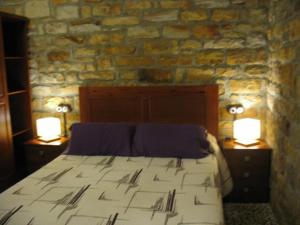 - une chambre avec un grand lit et 2 lampes sur les tables dans l'établissement Apartamentos Rurales KNICASIA, à Quintueles