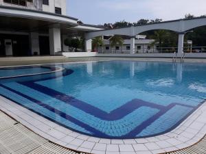 a large blue swimming pool in a building at Sunset view Apartment in Kuah
