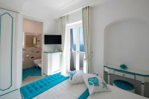a bedroom with a blue bed and a bathroom at Villa Viviani in Amalfi
