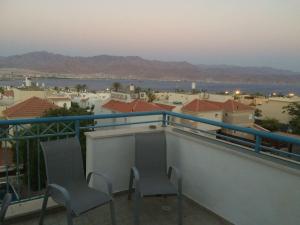 a balcony with two chairs and a view of a city at View House in Eilat